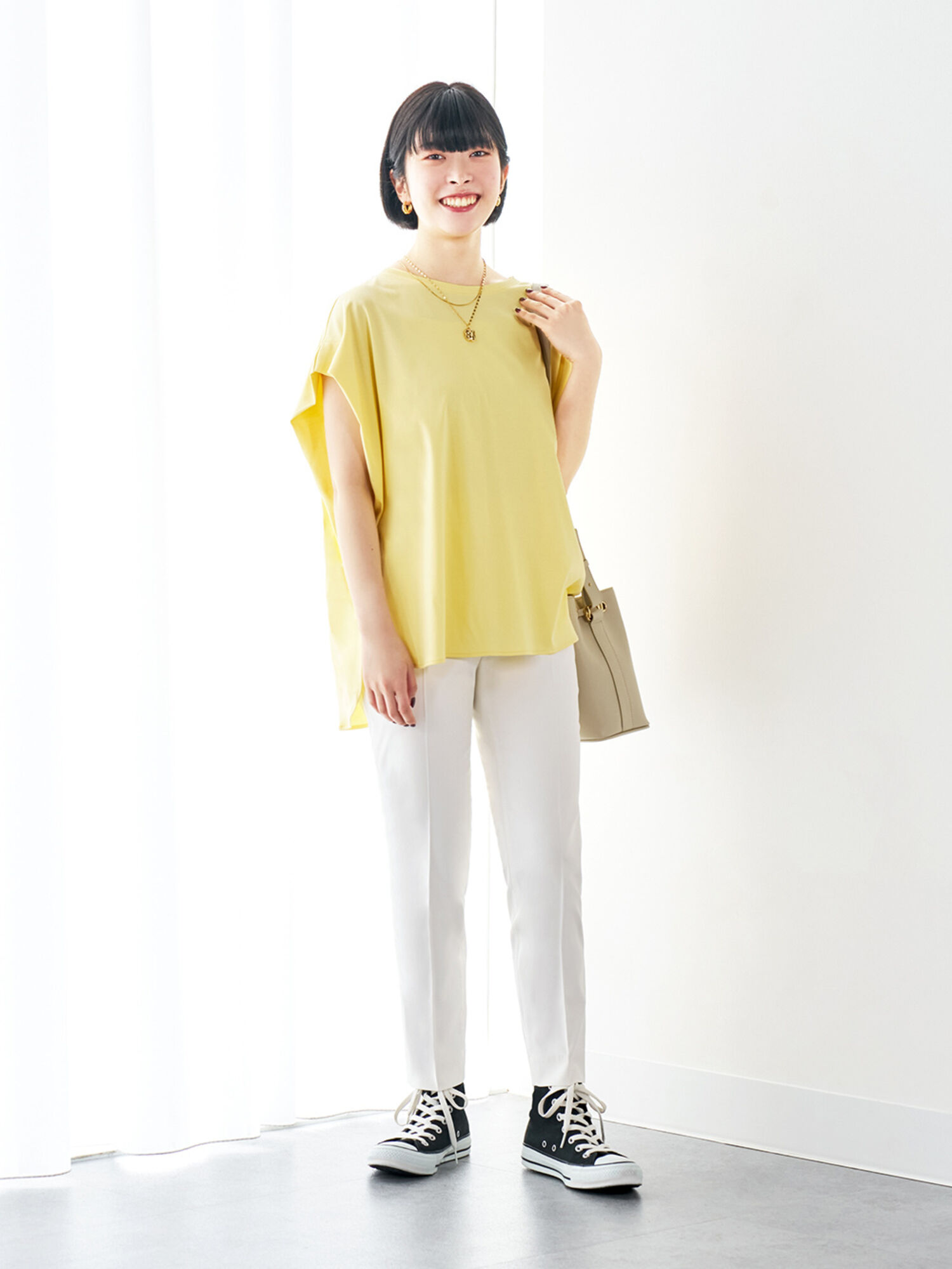 リラックスシルエットの鮮やかな黄色いトップスに白いボトムスを合わせたコーデ