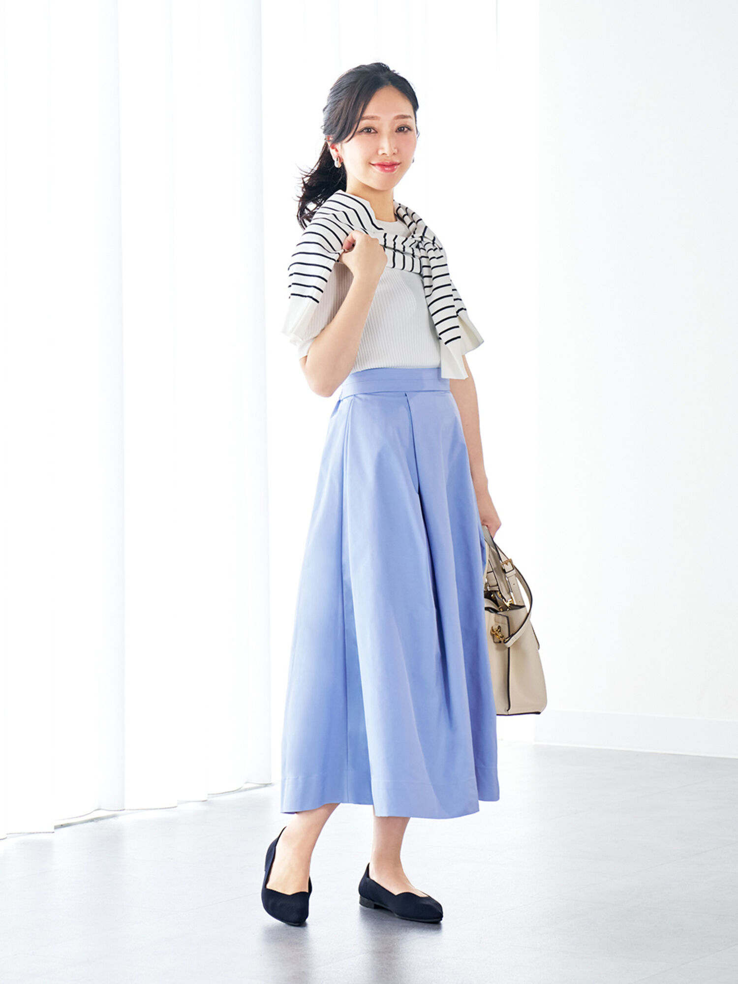 コンパクトなニットとボリュームのあるタックスカートを合わせた、フィット&フレアのコーデ