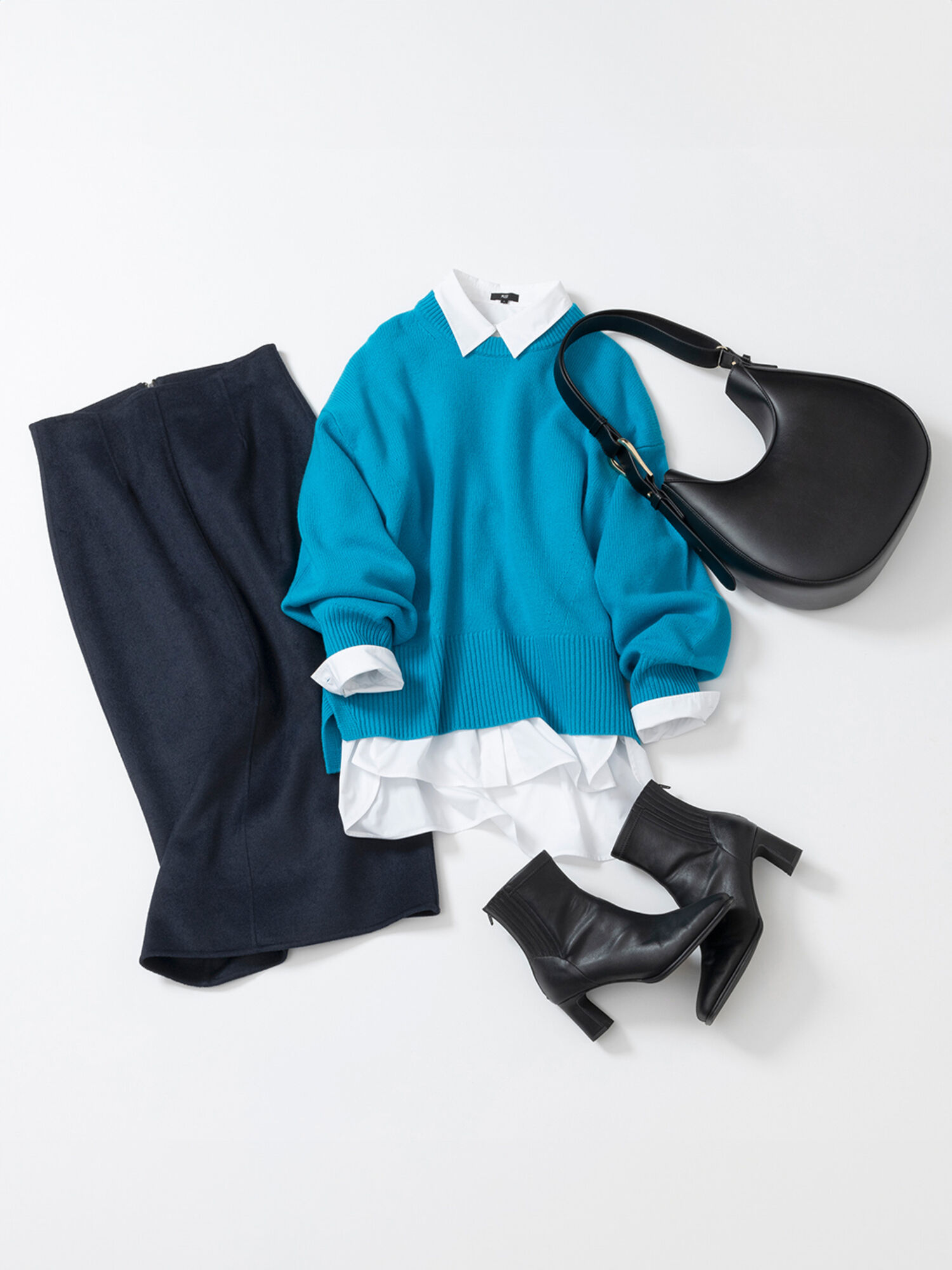 ターコイズブルーのニットと白シャツを重ね着したコーデ